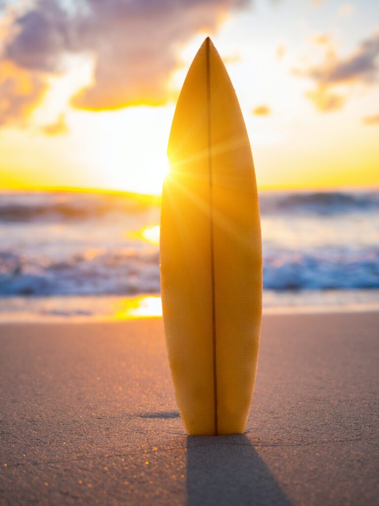 Surfboard on the beach at sunset